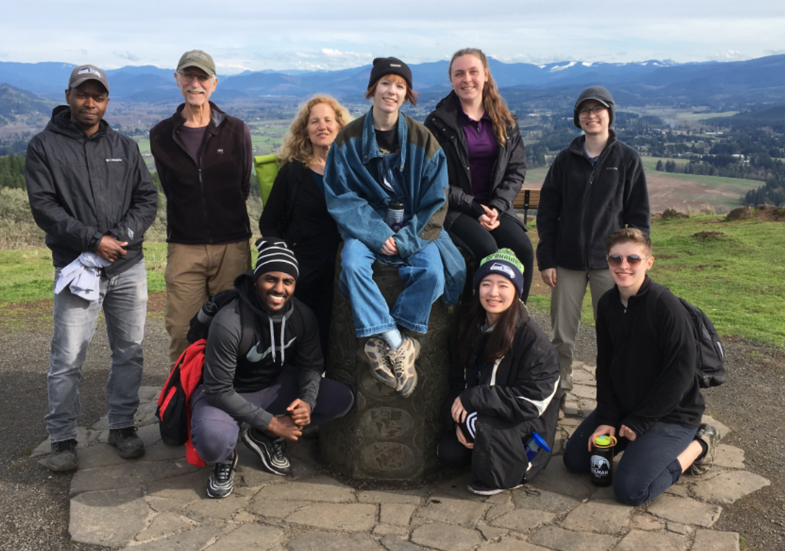 The Buford Park volunteer group is posed on and around a rock.