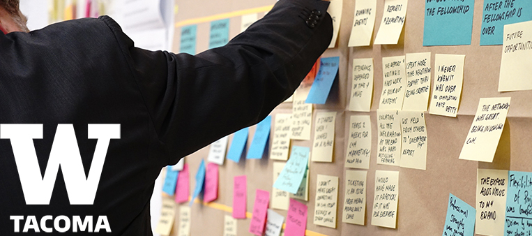 Man placing sticky note on cork board