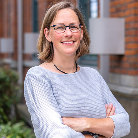 Headshot of UW Tacoma staff member Annemarie Martin. Marin is wearing a light colored top and her arms are crossed. She has brown hair and wears glasses.