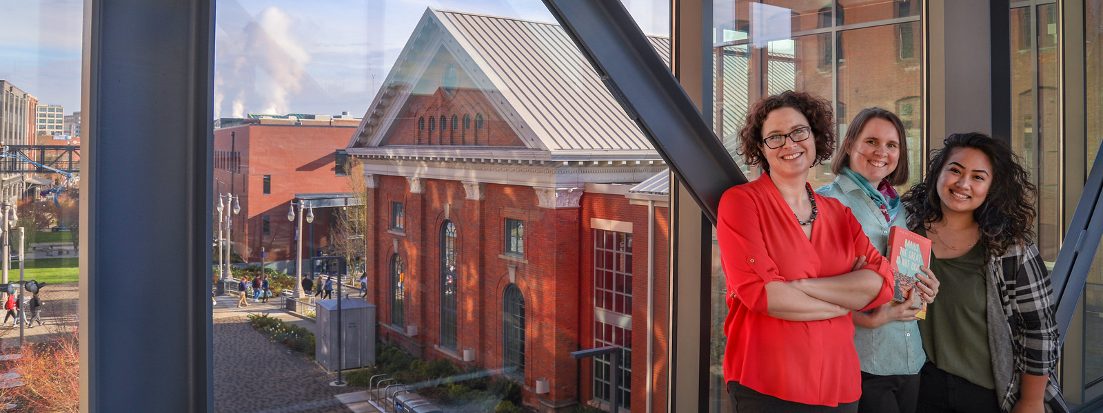 Johanna Jacobsen Kiciman, Kari Whitney and Nedralani Mailo pose in UW Tacoma Library bridge