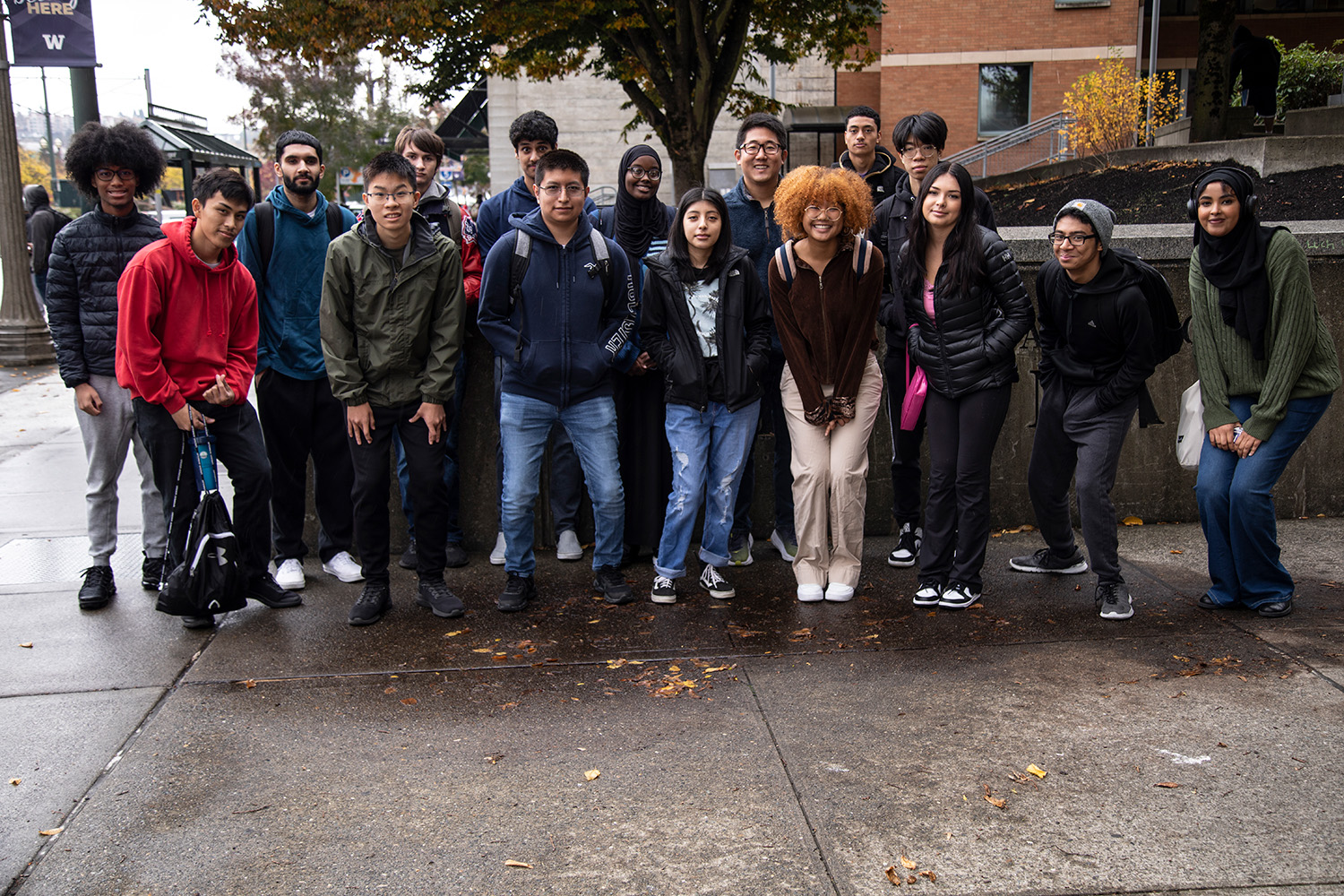 15 students in the T CORE 102 course pose for a group photo.