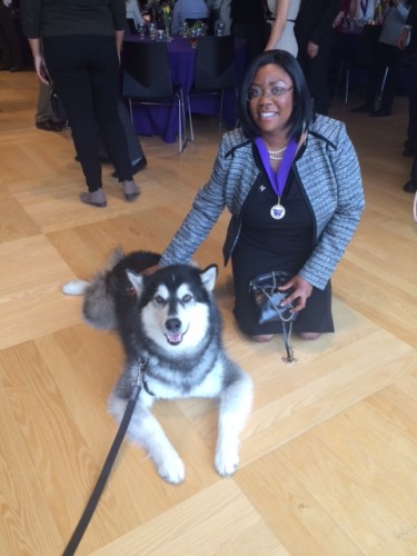 Regina Harper kneeling with UW live mascot.