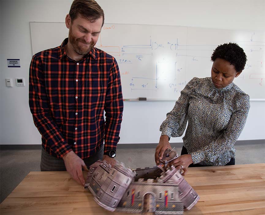 Jeff Walters and Angela Kitali breaking down a cardboard castle