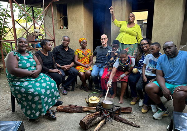 Picture of travel team members gathered around a traditional fire-cooked porridge.