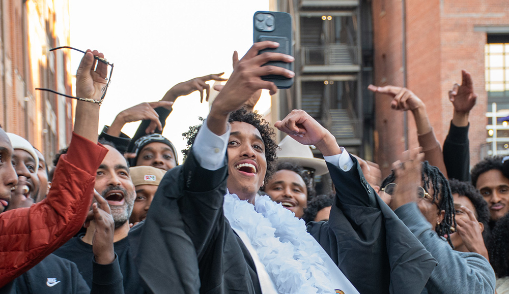 Photo of people celebrating a student in graduation regalia