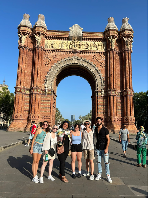 A group of people posing in front of the Arc de Triompf in Barcelona, Spain