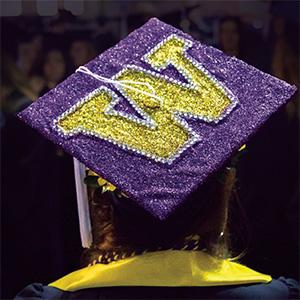 Photo of person wearing decorated graduation cap with the University logo