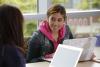 Student sitting at a table studying with a laptop.