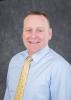 Professional photo of a white man in a yellow tie