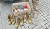 Box of supplies and boots next to legs and feet of Ukrainian soldier.