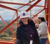 UW Tacoma mechanical engineering student Amy Keller at NASA Langley Research Center standing atop a horizontal drop-testing gantry crane.
