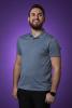 Photo of Evan Campbell in front of a purple backdrop looking upwards and forwards.