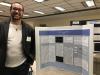 student standing in front of colloquium poster