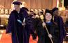 Faculty marshal Huatong Sun carries the UW Mace out of the Tacoma Dome to mark the end of the 2024 UW Tacoma Commencement.